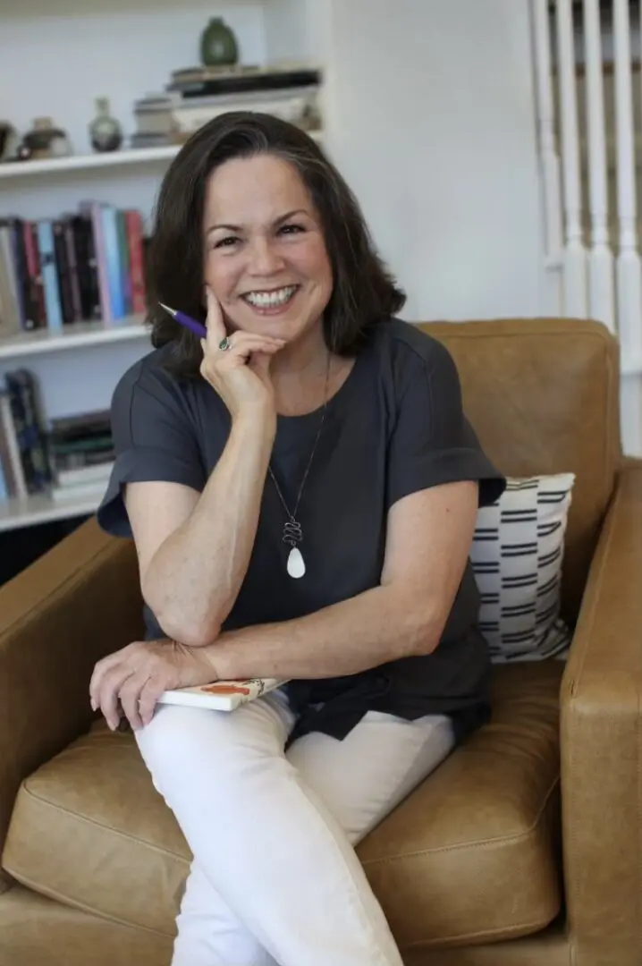 A woman sitting on top of a brown chair.